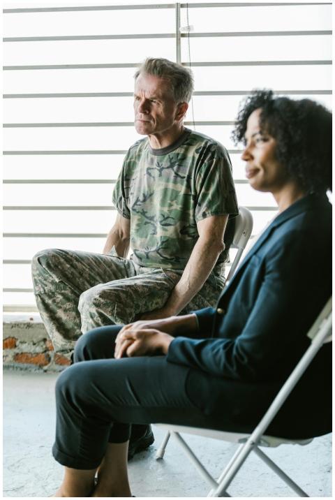 A military veteran in uniform sits with a counselo