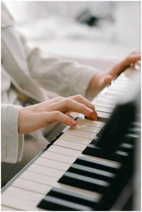 Close-up of a young person's hands playing a grand