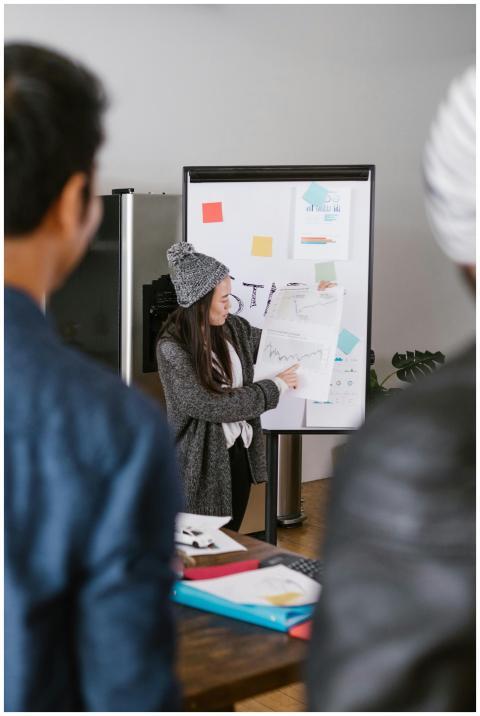 A young woman presenting business plans to a team