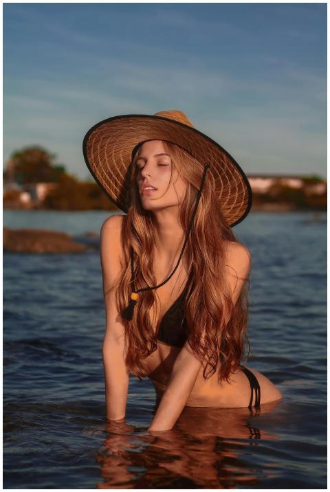 Beautiful woman in swimwear posing outdoors in tra