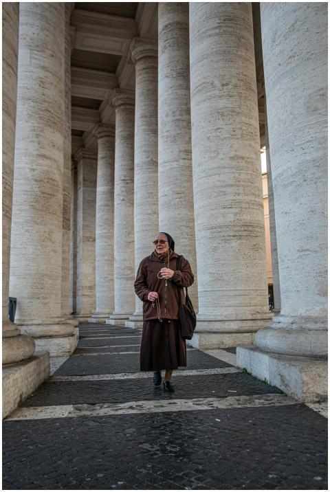 An elderly woman in traditional clothing walks amo