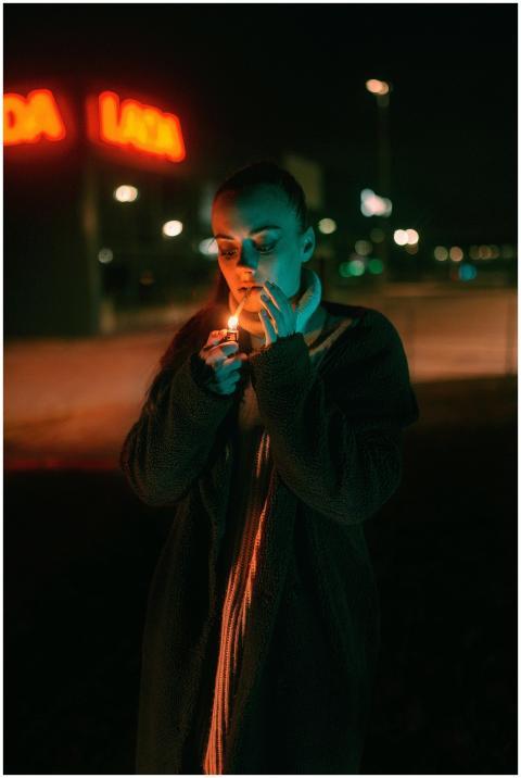 Moody portrait of a woman lighting a cigarette und