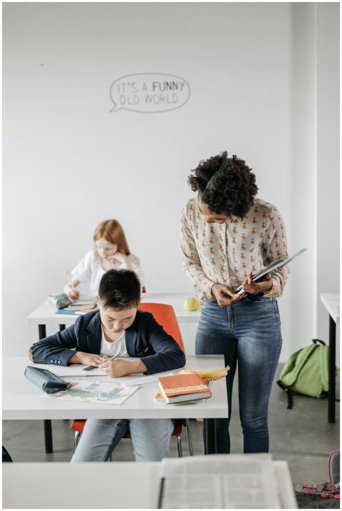 Teacher guiding students in a diverse, modern clas