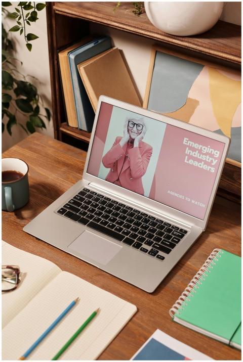 Stylish desk setup with a laptop, notebooks, and c