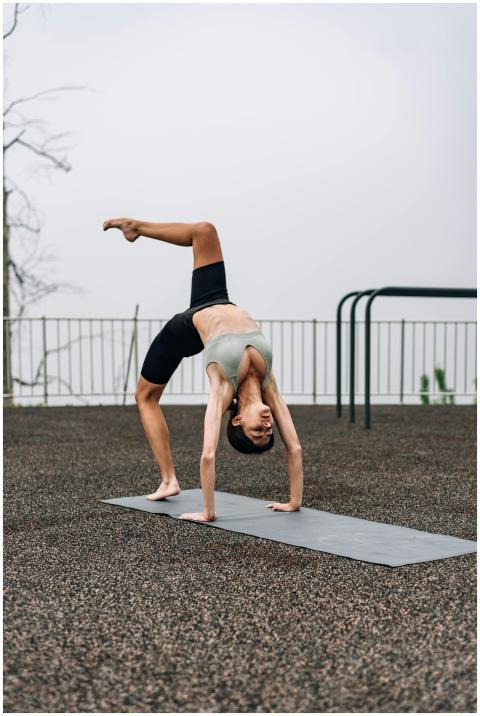 A woman in activewear performing a yoga pose outdo