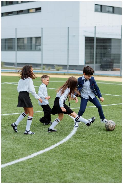 Group of children playing soccer on a school field