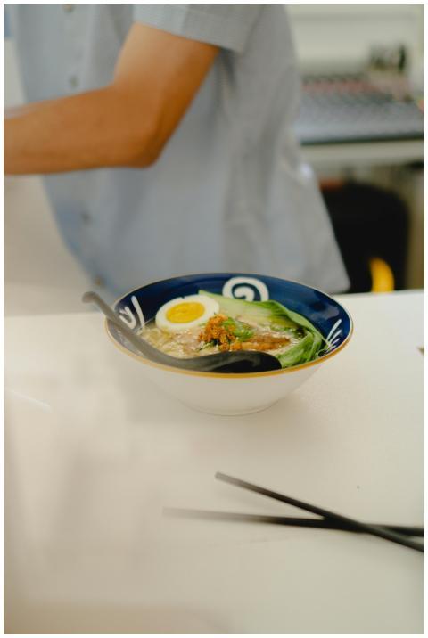 Appetizing ramen bowl with egg and greens, photogr