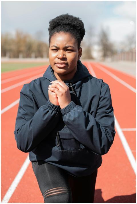 Black woman in activewear stretches for a workout
