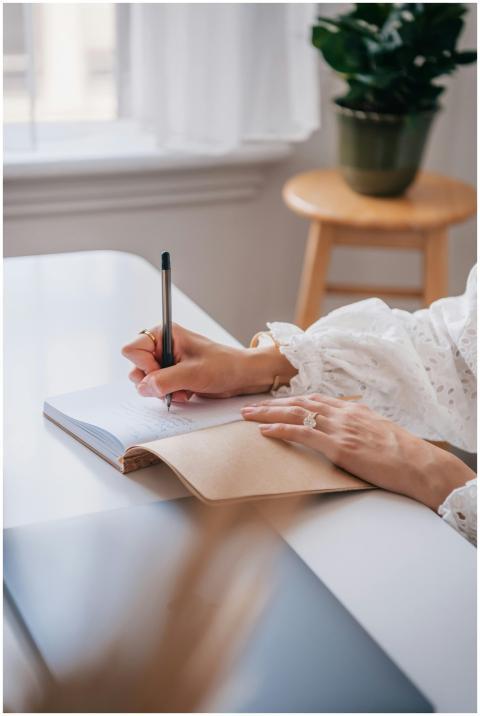 Close-up of a woman writing in a notebook at a bri
