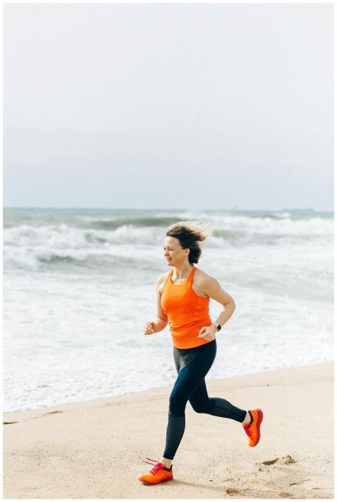 Caucasian woman jogging on the beach in orange tan