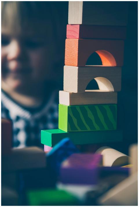 A child plays with colorful wooden blocks, buildin