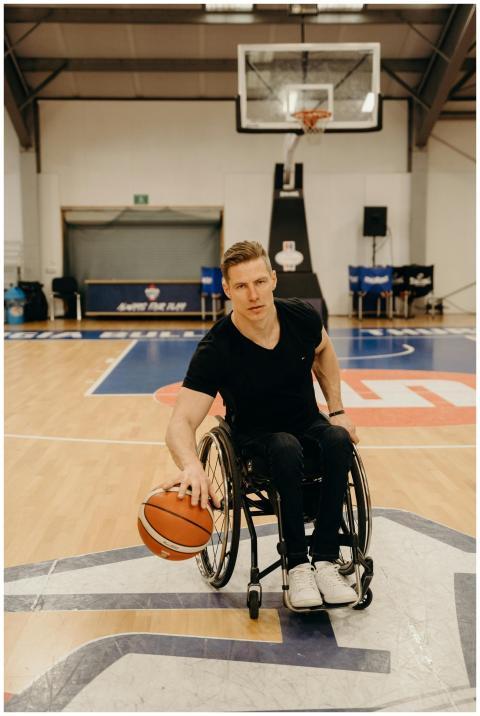 A determined wheelchair basketball player dribblin