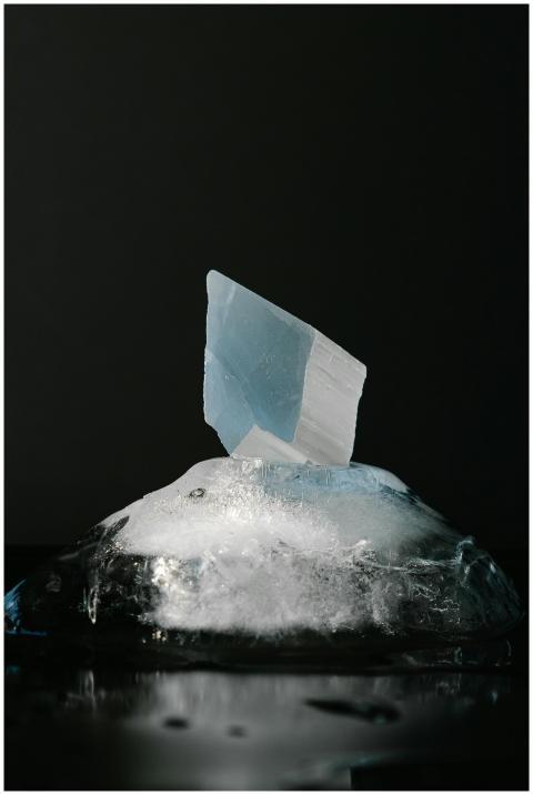 A shard of blue crystal emerging from a melting bl