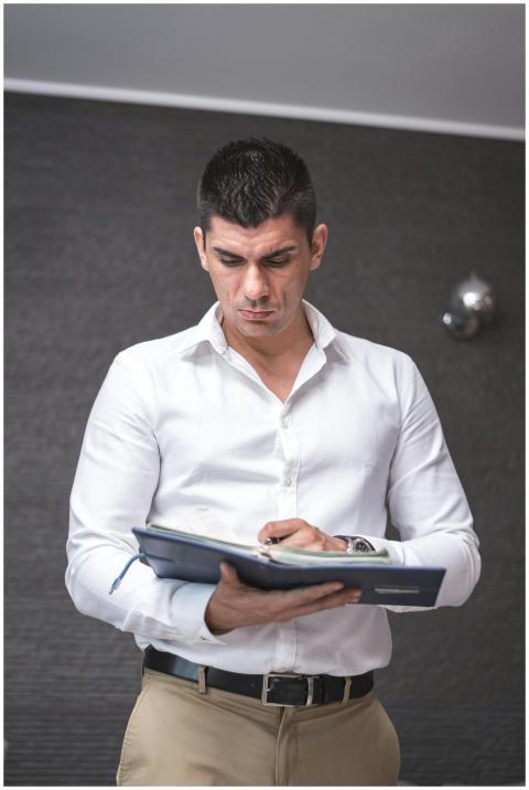 A businessman in a white shirt is reviewing docume
