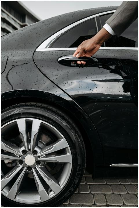 Close-up of a hand opening a black luxury car door