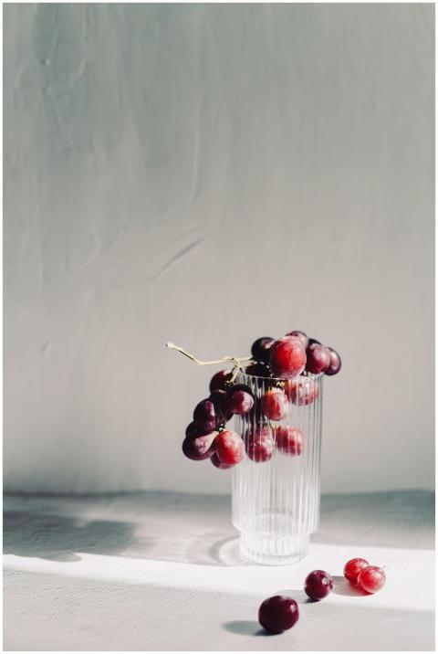 A minimalist still life of red grapes elegantly ar