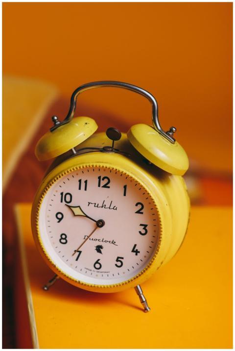A classic yellow alarm clock with a retro style on
