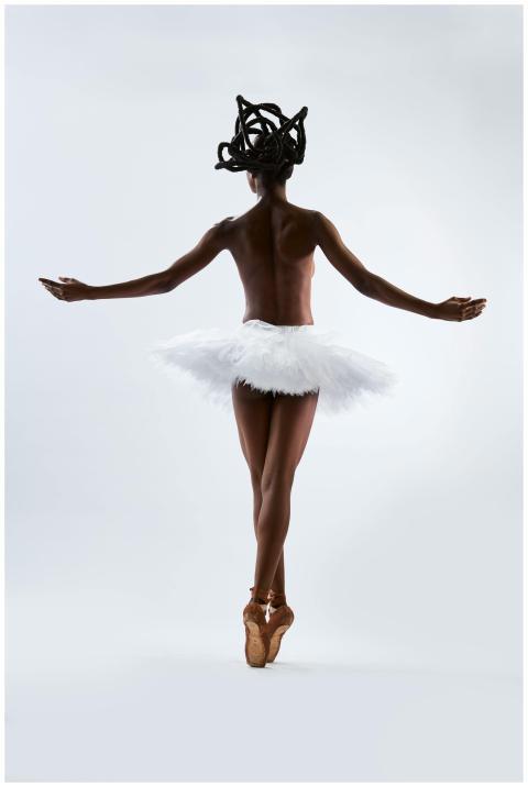 Ballet dancer posing gracefully in white tutu on s