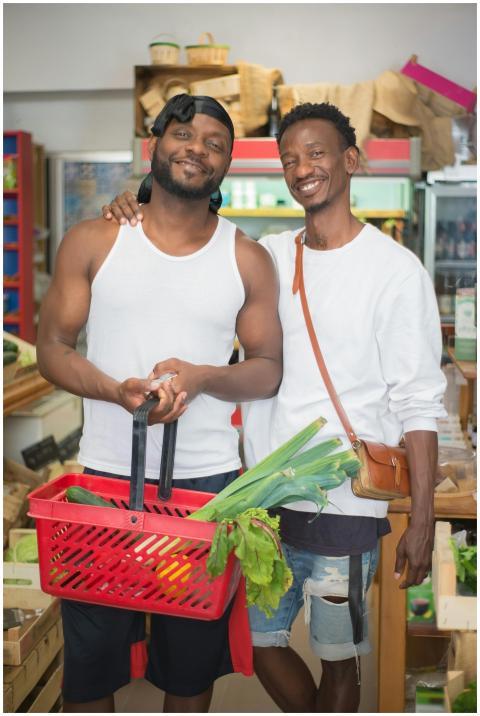 Happy couple shopping for vegetables at a local ma