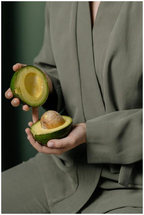 A person in green clothing holds a freshly sliced