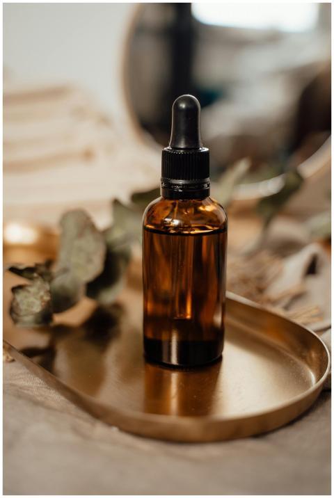 Amber glass dropper bottle on a wooden tray with a