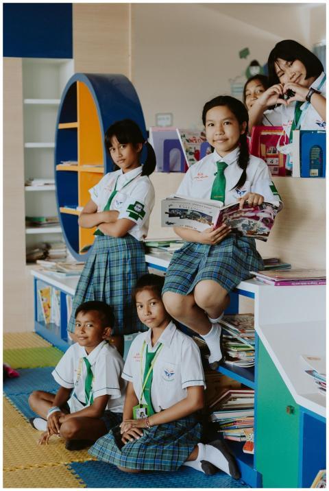 School children in uniforms reading together in a