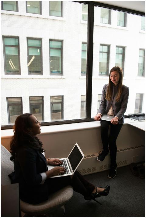 Two businesswomen discuss work in a contemporary o