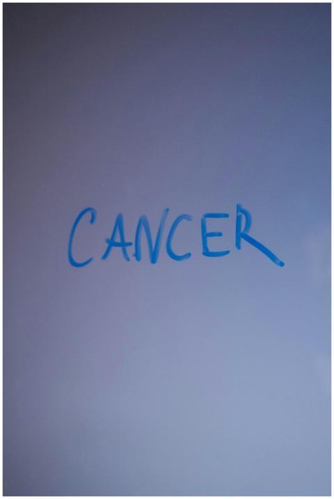 Close-up image of the word 'cancer' written in blu