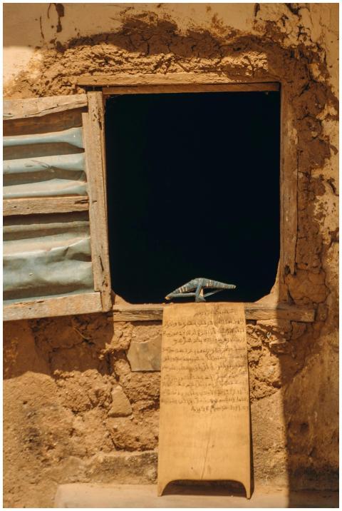 Rustic wall with an open window displaying an Arab