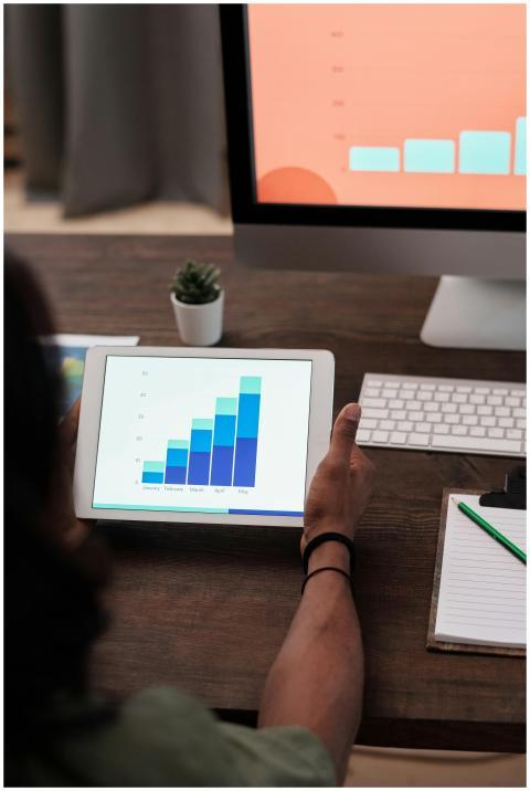 A person reviews statistical graphs on a tablet, s