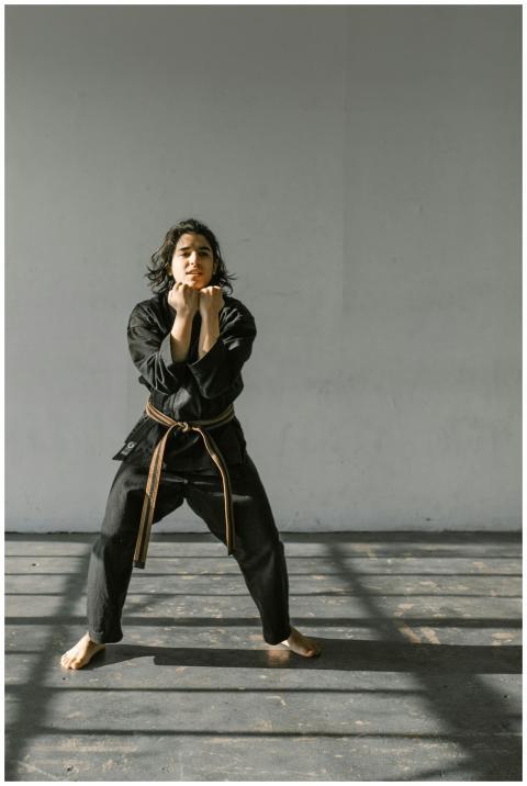 A young martial artist practices a karate stance i