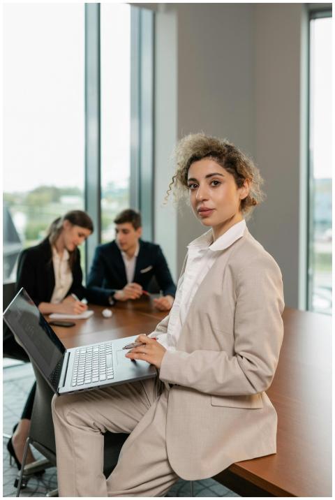 A professional woman in a beige suit working on a