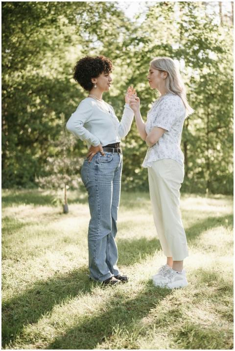 Two women express joy and connection outdoors, emb