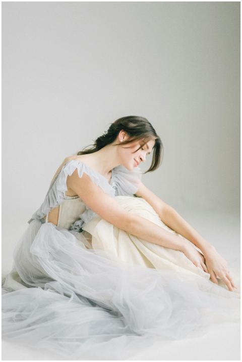 Graceful woman poses in soft light wearing a flowi