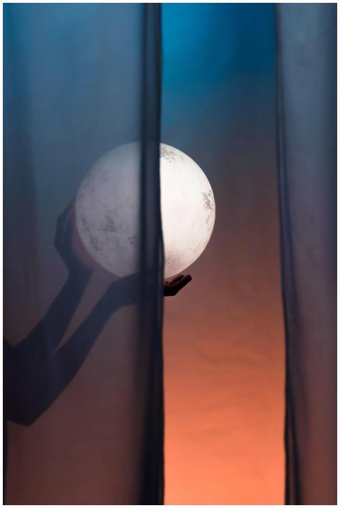 Artistic photo of a silhouette holding a moon-like