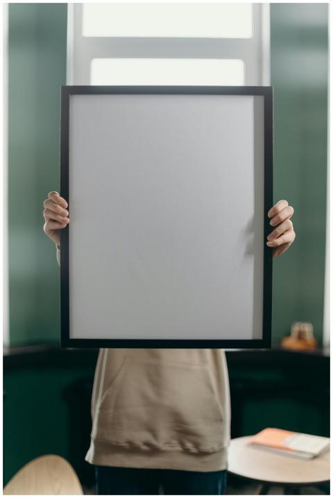 Anonymous person holds a blank vertical picture fr