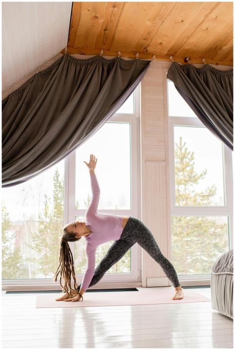 Woman doing a yoga pose indoors with natural light