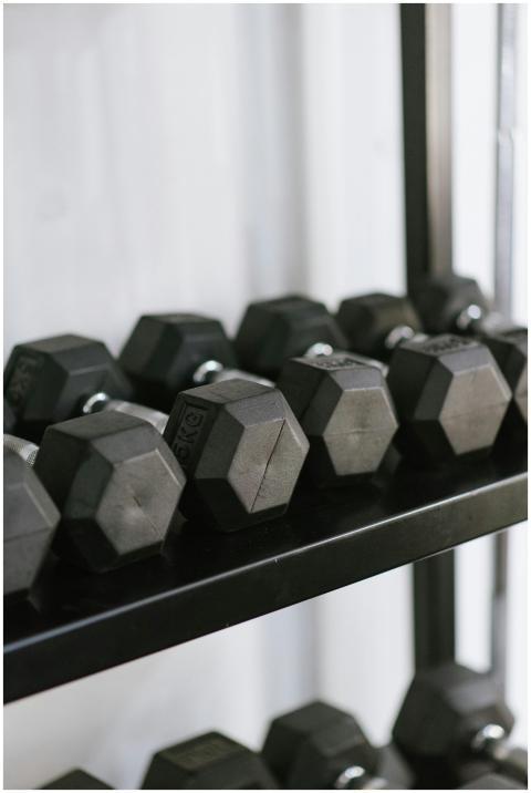 Row of black hexagonal dumbbells neatly stored on