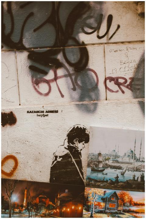 Graffiti and art posters on urban wall, showcasing