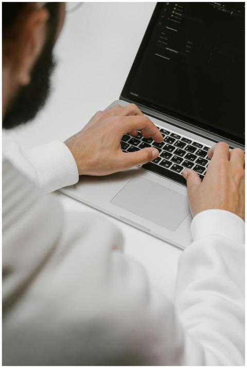 A male programmer intensely typing code on a lapto