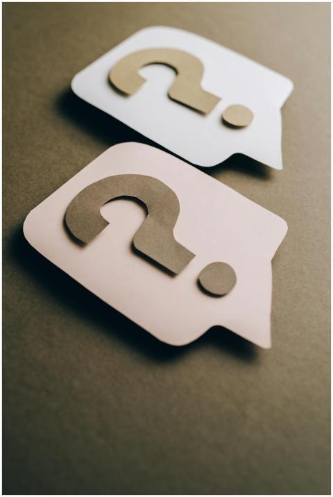 Two paper craft question marks on speech bubbles c