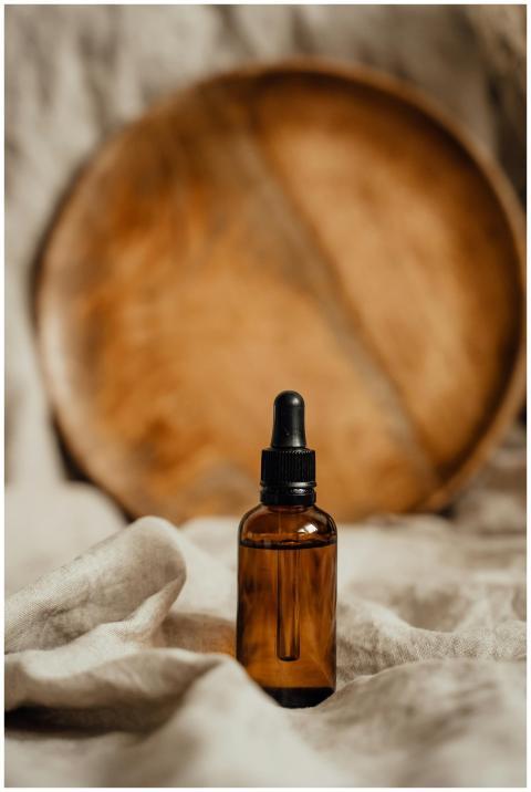 Amber glass dropper bottle with rustic wooden back