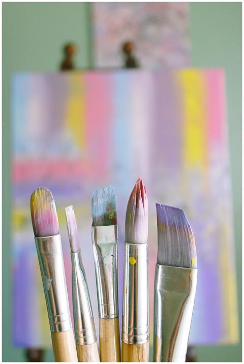 Art brushes with abstract painted canvas in vibran