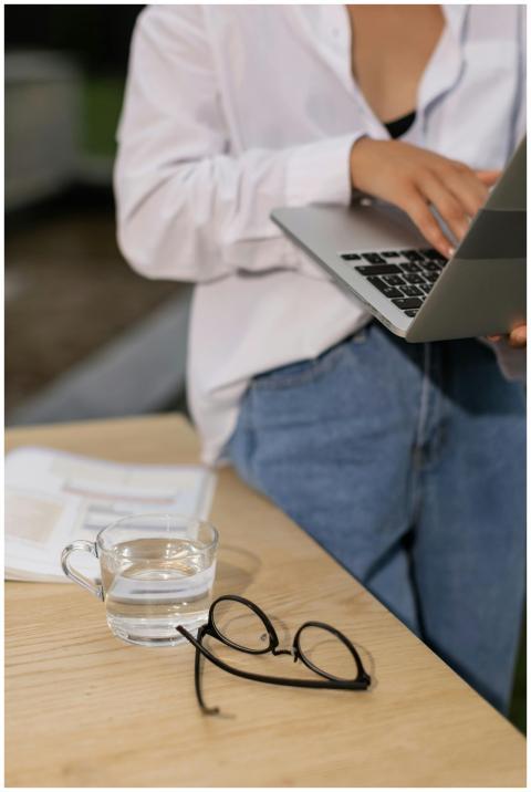 Casual woman typing on laptop with eyeglasses and