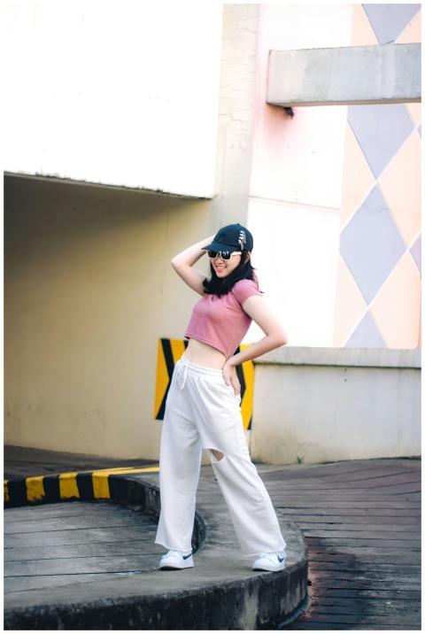 Stylish woman in pink crop top and jogger pants po