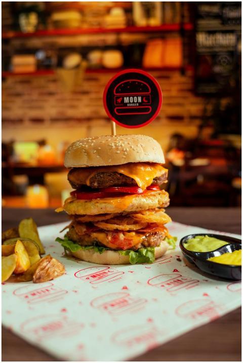 Juicy gourmet cheeseburger stacked with layers and