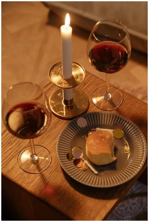 Elegant dessert setup with wine glasses and candle