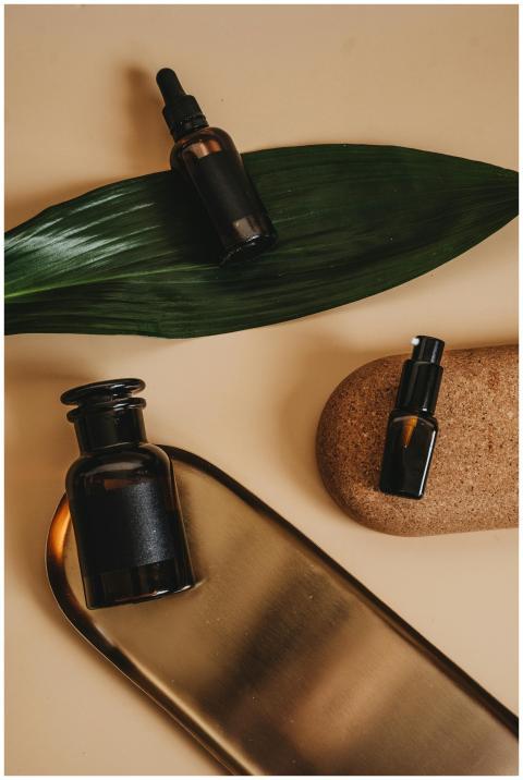 Stylish arrangement of cosmetic bottles with leaf