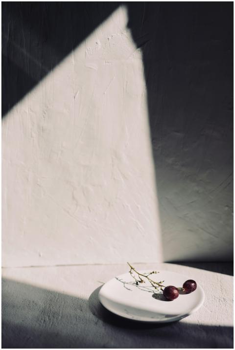 Artistic still life featuring grapes on a ceramic