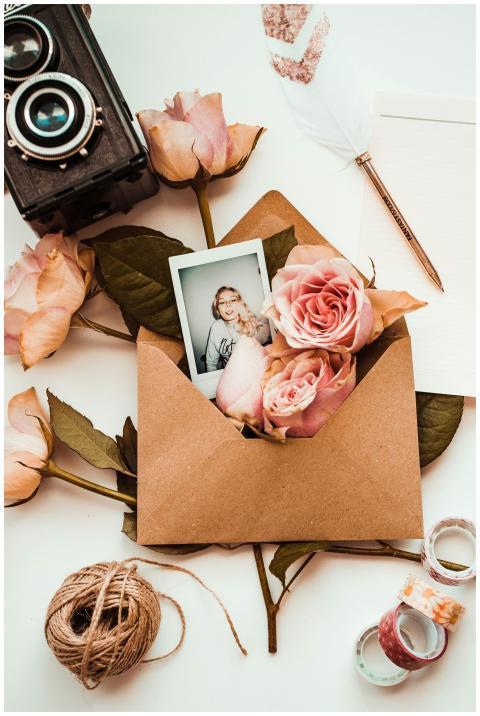 Aesthetic flatlay with a Polaroid, roses, envelope